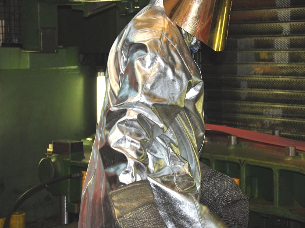 Warmumformung von Prototypenteilen – Arbeitsschutz bei Hochtemperaturprozessen Mitarbeiter in Hitzeschutzkleidung während der Warmumformung eines Prototypenteils