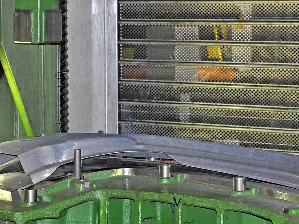 Warmumformung von Prototypenteilen – Hochtemperatur-Umformprozess Prototypenteil während der Warmumformung auf einem Formwerkzeug in der Fertigung