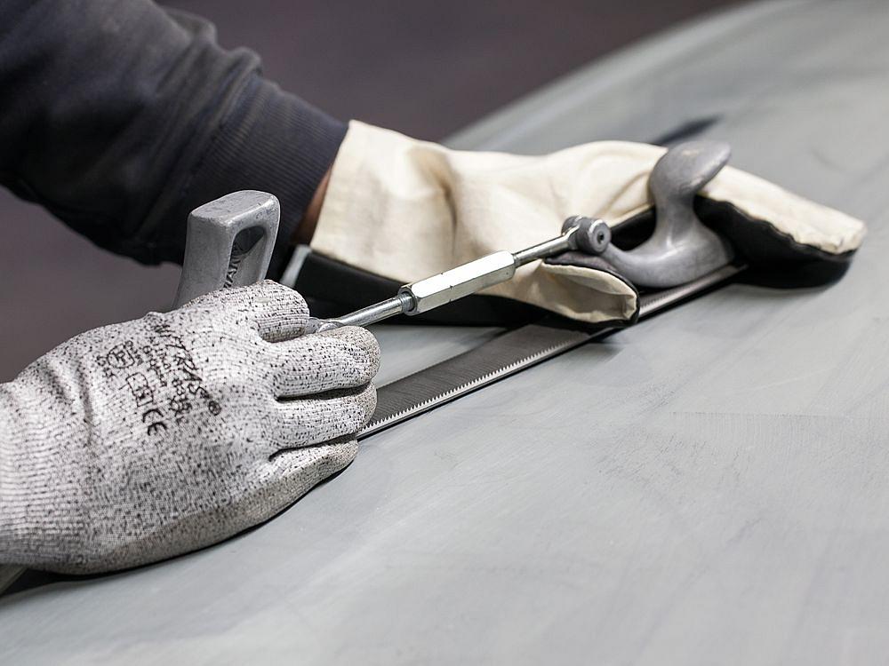 Close-up of manual prototype processing using a file and precision tools